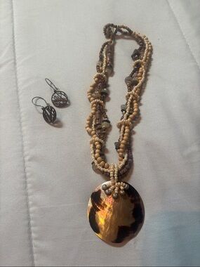 boho-style beaded statement necklace featuring a large abalone shell pendant